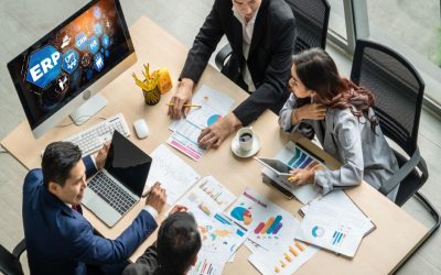 Description: Accounting team of men and women collaborating on ERP planning at desk with computer to analyze performance and create reports for operations management.