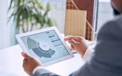 Male CFO in office using tablet with cashflow graph view in dashboard of cloud ERP software, working on expense management